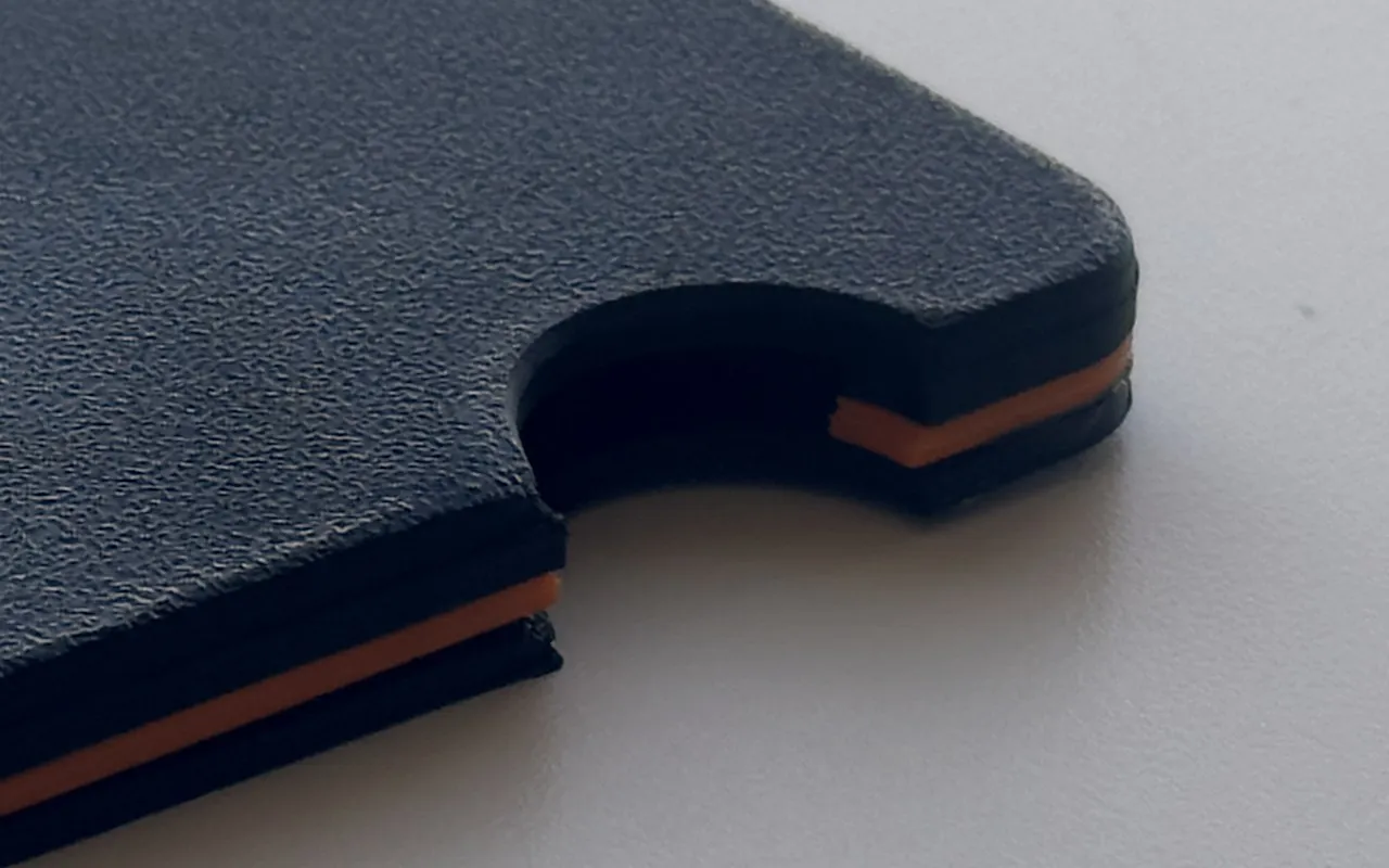Close-up of prototype 1 at the thumb cutout: the orange layers between the plates.
